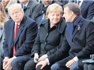  ??  ?? French President Emmanuel Macron, right, touches the knee of German Chancellor Angela Merkel as they sit next to US President Donald Trump during a ceremony marking the 100th anniversar­y of the end of World War I in Paris on Sunday.