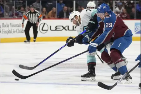  ?? DAVID ZALUBOWSKI — THE ASSOCIATED PRESS ?? Seattle Kraken right wing Jordan Eberle, left, shoots as Avalanche center Nathan Mackinnon defends during the second period of Friday night’s game at Ball Arena.