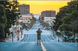  ?? Irfan Khan Los Angeles Times ?? A MAN stops to photograph a deserted Colorado Boulevard on Jan. 1 after the Rose Parade was canceled for the first time in 75 years because of COVID-19.