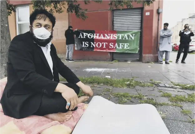  ??  ?? 0 Abdul Rahman Safi from Afghanista­n yesterday stitched his lips togethern then began a hunger strike in front of the Home Office building on Brand Street in Glasgow