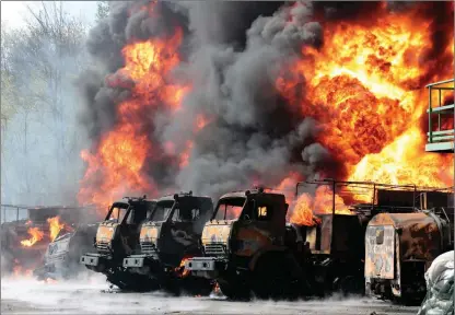  ?? The Associated Press ?? Vehicles burn at an oil depot in Makiivka, east of Donetsk, Ukraine, on Wednesday after missiles struck the facility in an area controlled by Russian-backed separatist forces.