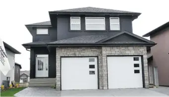  ?? JEFF LYONS/THE Starphoeni­x photos ?? Selkirk Developmen­ts’ latest show home at 438 Hastings Crescent offers contempora­ry street appeal with
stone work, modern garage door design and a stained-glass window in the front door.