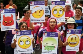  ??  ?? Faces of dissent: Various activist groups holding emoji-based placards as they join other protesters in airing their concerns marking Duterte’s first year in office outside the presidenti­al palace in Manila. — Reuters