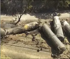  ??  ?? In this June 6, 2016, file aerial video image taken from a drone, crumpled oil tankers lie beside the railroad tracks after a fiery train derailment that prompted evacuation­s from the tiny Columbia River Gorge town of Mosier, Ore. BRENT FOSTER VIA AP