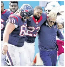 ?? WILFREDO LEE / ASSOCIATED PRESS ?? Texans running back Arian Foster is helped off the field after tearing
his Achilles tendon in the 44-26 loss on Sunday to the Dolphins. Foster is due to have an MRI exam on Monday.