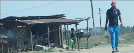  ?? ?? The Times of Eswatini reporter with the two-litre of petrol which he bought from the market stall.