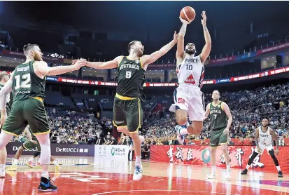  ??  ?? France’s Evan Fournier jumps with the ball as Australia’s Matthew Dellavedov­a (center) tries to block during their 2019 FIBA Basketball World Cup Group L second-round game in Nanjing, east China’s Jiangsu Province, last night. Australia won 100-98. — AFP