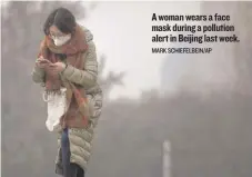  ?? MARK SCHIEFELBE­IN/ AP ?? Awoman wears a face mask during a pollution alert in Beijing last week.