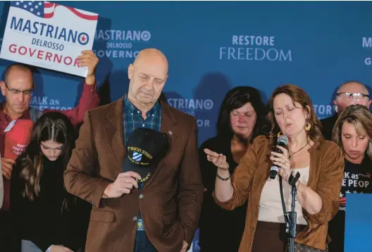  ?? FILE ?? Doug Mastriano, the Republican nominee for Pennsylvan­ia governor, and his wife, Rebbie, pray with supporters during his election night party on Nov. 8 in Camp Hill.