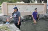  ?? Billy Calzada / San Antonio Express-News ?? With the pool closed, people play in Main Canal in Balmorhea.