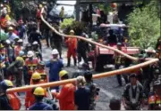  ?? SAKCHAI LALIT — THE ASSOCIATED PRESS ?? Rescuers carrying water pipe make their way to the entrance of a cave complex where 12 boys and their soccer coach were trapped inside when heavy rains flooded the cave, in Mae Sai, Chiang Rai province, in northern Thailand, Wednesday. The Thai soccer teammates said they were healthy on a video.