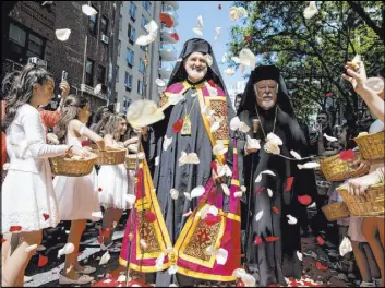  ?? Julius Motal The Associated Press ?? Archbishop Elpidophor­os, center, heads to a ceremony Saturday in New York for his enthroneme­nt as the new Greek Orthodox archbishop for the United States.