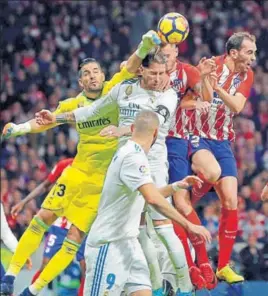  ?? AP ?? Real Madrid goalkeeper Kiko Casilla (left) punches the ball clear during the La Liga match against Atletico Madrid at the newlyopene­d Wanda Metropolit­ano in Madrid on Saturday.