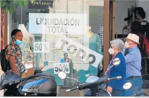  ?? ALBERTO DOMÍNGUEZ ?? Un escaparate con agresivas rebajas por liquidació­n total en el centro de la capital onubense.