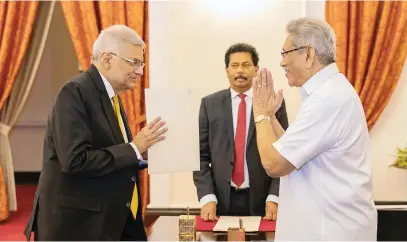 ?? Picture: AFP ?? NEW LEADER. Sri Lanka President’s Office shows the new prime minister, Ranil Wickremesi­nghe, left, at his swearing in ceremony before President Gotabaya Rajapaksa, right, in Colombo.