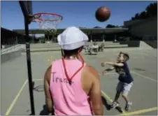  ?? JEFF CHIU — THE ASSOCIATED PRESS ?? Camp instructor Kris Gambardell­a watches as camper Wilson shoots baskets at the Bay Area Rainbow Day Camp in El Cerrito Tuesday. Gender experts say Rainbow’s rapid growth reflects what they’re seeing in gender clinics around the country: an increasing number of kids coming out as transgende­r at young ages.