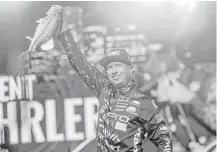  ?? Elizabeth Conley / Houston Chronicle ?? Brent Ehrler shows off one of the five largemouth­s he yanked from Lake Conroe on Saturday to lead the Bassmaster Classic.