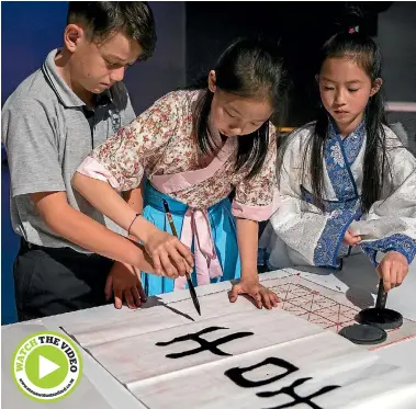  ?? PHOTO: MURRAY WILSON/STUFF ?? Boys’ high students being taught calligraph­y. From left, Te-ahu James Roberts, Deng Nanxi, and Zhang Chenmeng.