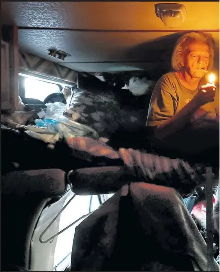  ??  ?? SHARON MANLEY lights up a cigarette inside the recreation­al vehicle she shares with her longtime companion, Kraig Goins, 19 years her junior. Manley suffers from chronic obstructiv­e pulmonary disease and early-stage dementia. She has no health insurance