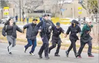  ?? Matthew Jonas Boulder Daily Camera ?? Police, King Soopers employees and customers run down Table Mesa Drive in Boulder, Colo., on Monday after a shooting erupted that killed 10 people at the grocery store.