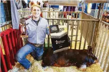  ?? Michael Ciaglo / Houston Chronicle ?? Cody Wolf, 17, kneels with his 280-pound champion pig Monday at the Houston Livestock Show and Rodeo.