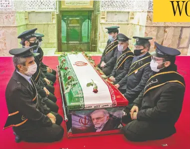 ?? HAMED MALEKPOUR / TASNIM NEWS / AFP VIA GETTY IMAGES ?? Members of Iranian forces pray around the coffin of slain scientist Mohsen Fakhrizade­h in northern Tehran Monday.