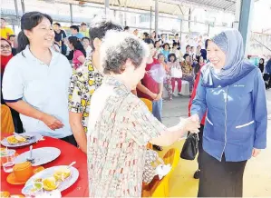  ??  ?? AZIZAH (kanan) bersalaman dengan sebahagian masyarakat yang hadir ketika tiba pada majlis itu.