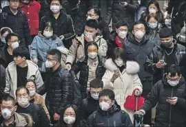  ?? Kevin Frayer Getty Images ?? PASSENGERS in Beijing prepare to board trains last week. Chinese authoritie­s have placed 17 cities under lockdown amid a deadly coronaviru­s outbreak.