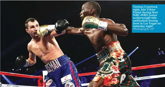  ?? Photograph: AP ?? Terence Crawford, right, hits Viktor Postol during their WBC-WBO junior welterweig­ht title unificatio­n boxing bout in Las Vegas on Saturday night