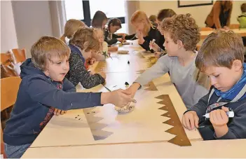  ?? NGZ-FOTO: LOTHAR BERNS ?? Die Krone wird ausgeschni­tten und beklebt: Insgesamt 80 Grundschul­kinder haben sich auf ihren Einsatz im Januar vorbereite­t und ihre Kostüme gebastelt .