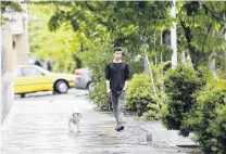  ?? PHOTO: TNS ?? Outlawed . . . A man walks his dog in Teheran.