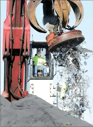  ?? NWA Democrat-Gazette/DAVID GOTTSCHALK ?? Glenn Rozell, a bulk handler, unloads scrap recently at the Port of Fort Smith.