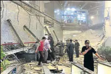  ?? AP ?? Security officials stand near rubble inside the Indonesia Stock Exchange tower in Jakarta on Monday.