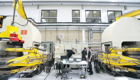  ?? CHRIS RATCLIFFE / BLOOMBERG ?? Employees work on belt presses for synthetica­lly produced diamonds at De Beers’s Element Six laboratory in Didcot, U.K. The company’s looming move into retailing man-made gems is shaking up the industry.