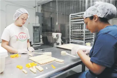  ?? Suministra­da ?? Empleadas de Yemi, en el proceso de elabor los “deditos” de queso. Abajo, Jezreel García, junto a su esposa Sharayma Bey, propietari­os de la manufactur­era.