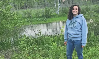  ?? VIDDY WABINDATO ?? Hannah Arbuckle stands in front of the Kakagon Slough on Bad River where manoomin (wild rice) is harvested. Arbuckle says manoomin in the Ojibwe language means “the good berry.” Arbuckle has an internship working for the Great Lakes Indian Fish and Wildlife Commission on the Bad River Reservatio­n.