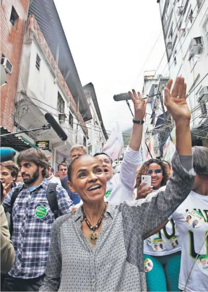  ??  ?? ► La candidata Marina Silva saluda a sus partidario­s en el barrio de Rocinha en Río de Janeiro.