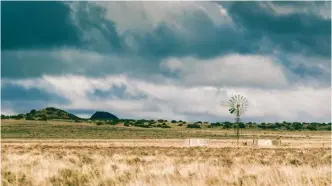  ??  ?? Grasvlakte­s gemeng met bossies... dit is immers Vrystaat én Karoo dié. ’n Windpomp wat sy kop bo die horison uitsteek – en swaar wolke wat die hemelruim vul – rond die prentjie af. Én maak die boere bly.