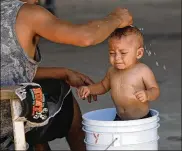  ?? MARCO UGARTE / ASSOCIATED PRESS ?? A migrant baby is given a bath at the AMAR migrant shelter housing asylum seekers in Nuevo Laredo, Mexico, Tuesday.