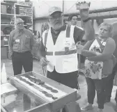  ?? JOSH FUNK/AP ?? Niocorp controller Jeff Mason shows investors a rock sample in October in Elk Creek, Nebraska. Mark Smith, CEO of Niocorp, stands to the left.