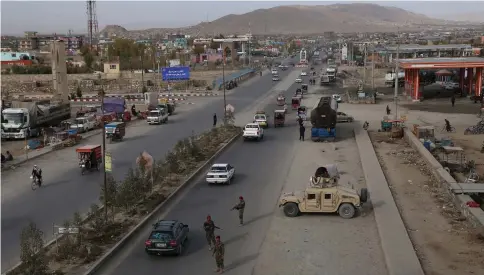  ??  ?? Afghan security personnel search passengers in a checkpoint on Highway One in Ghazni. — AFP photo by Zakeria Hashimi