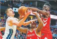  ?? Jack Dempsey, The Associated Press ?? Nuggets center Nikola Jokic, left, battles Houston Rockets PJ Tucker and Clint Capela for a loose ball Sunday.