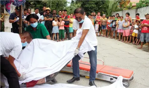  ??  ?? Funeral workers carry the body of shooting victim Vic Pilares in Barangay Cubacub, Mandaue City. JOY TORREJOS