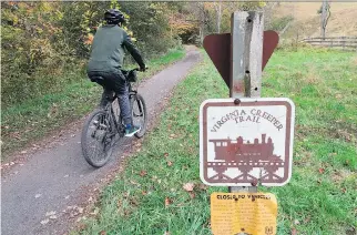  ?? PHOTOS: KAREN TESTA/THE ASSOCIATED PRESS ?? A cyclist rides through the Virginia Creeper Trail. Local outfitters rent bikes, including some with “comfort seats” for a slight upcharge.