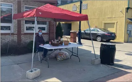  ?? SARAH WRIGHT — MORNING SUN ?? Art Reach of Mid Michigan administra­tive coordinato­r Kim Bigard and her daughter handing out at goody bags at the CFX and Mt. Pleasant Parks and Recreation Great Egg Rec N’ Ramble behind the Art Reach building.