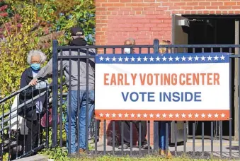  ?? MICHAEL PEREZ/ASSOCIATED PRESS ?? Voters line up at an early voting location at an elementary school in Philadelph­ia Thursday. A surge in coronaviru­s cases is hitting presidenti­al battlegrou­nd states as possible chaos looms on Election Day.