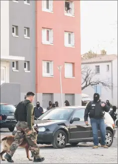  ??  ?? Residents look from the window as a members of the French Research and Interventi­on Brigade (BRI) secure the area during a search operation at the Ozanam housing estate in Carcassonn­e, southweste­rn France following the shooting dead by French security officers of an armed hostage taker who is believed to have links to the estate. — AFP photo