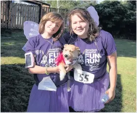  ??  ?? ON TWO LEGS AND FOUR: Runners, some dressed in fairy wings and tutus, joined in the fun while helping to raise cash for Harefield Hospital