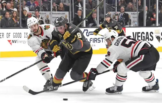  ?? | ETHAN MILLER/ GETTY IMAGES ?? Hawks defensemen Brent Seabrook ( left) and Erik Gustafsson battle the Golden Knights’ Reilly Smith for control of the puck Tuesday in Las Vegas.