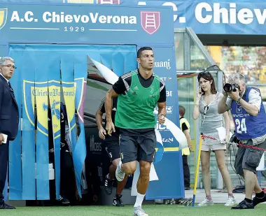  ??  ?? Il popolo di Ronaldo A sinistra, l’ingresso al campo per il riscaldame­nto di Cristiano Ronaldo, accolto da un’autentica ovazione da parte dello stadio. A destra, in alto, una bambina mostra un libro con l’immagine del campione portoghese. Sotto, altri bambini con l’effige cartonata di Cristiano Ronaldo quando ancora vestiva la maglia del Real Madrid, squadra con cui ha vinto le ultime tre Champions League